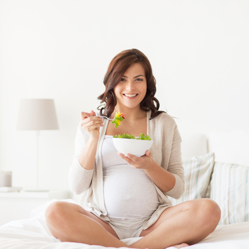 Pregnant woman eating a salad