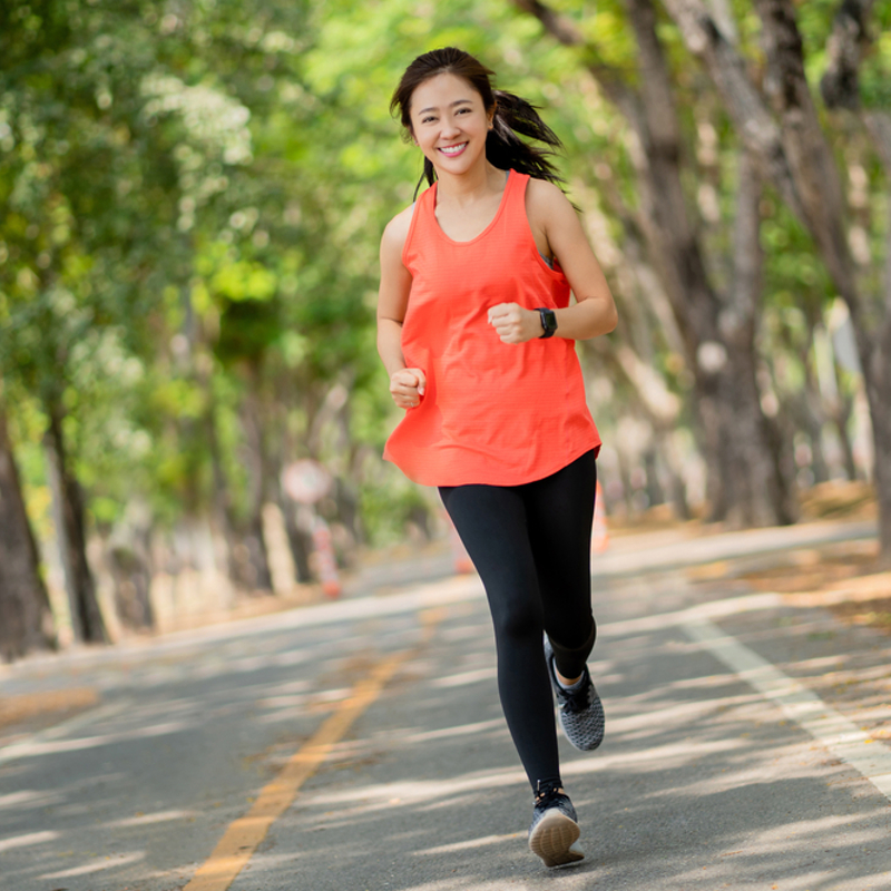 زن جوان در حال دویدن در پارک