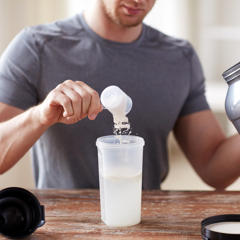 A man making a protein shake with protein powder