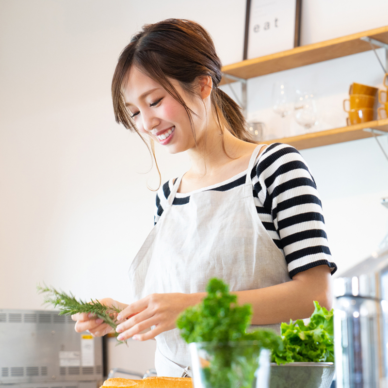 A woman preparing herbs cooking in the kitchen