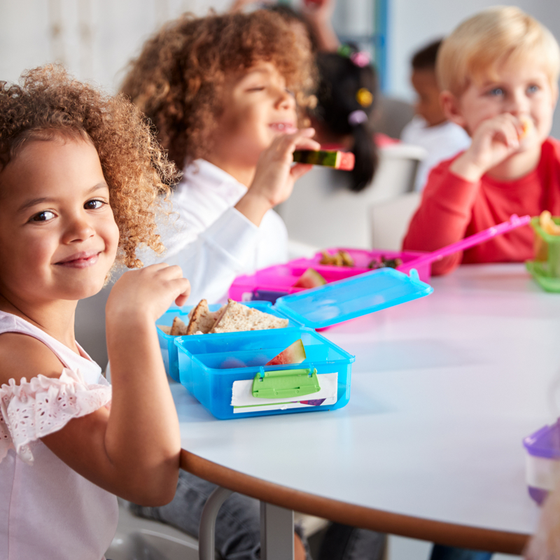 Young children eating their packed lunches at school