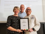 A photo of a teacher receiving her award from Gary Mclean at the Scottish Conference