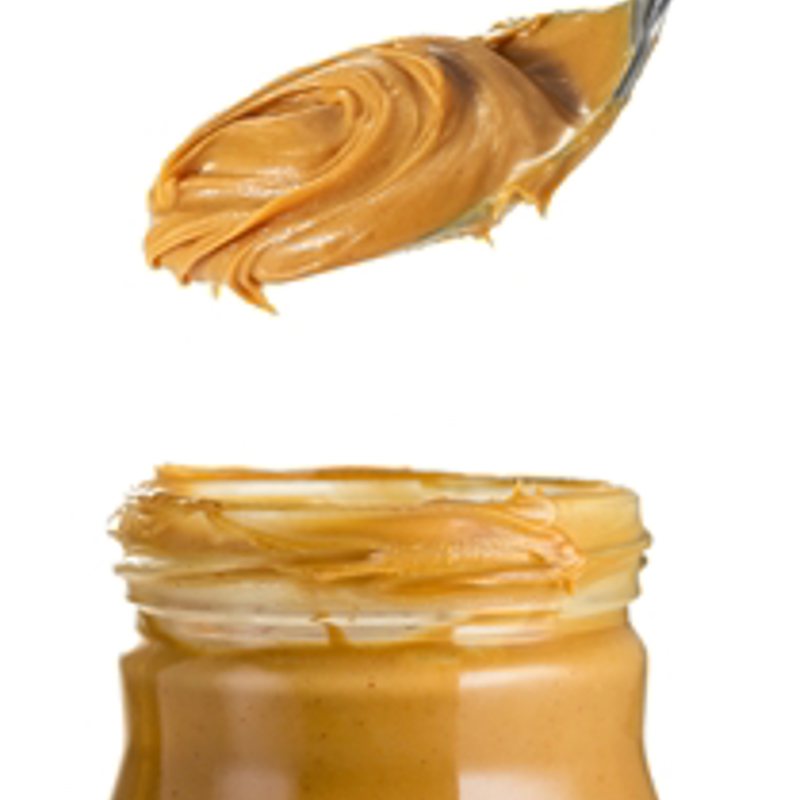 A spoon of peanut butter out of the jar