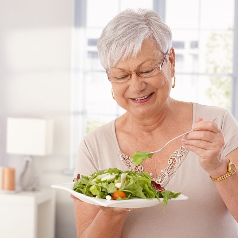 An older woman eating a salad
