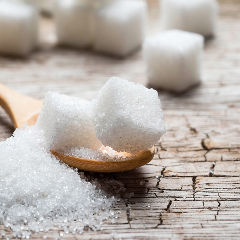 Sugar cubes and granulated sugar on a wooden spoon