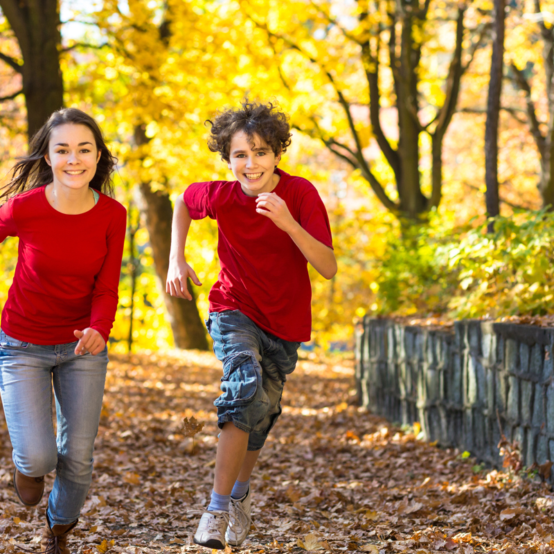 A girl and boy running outside