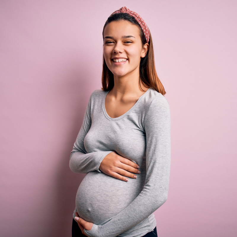 Young pregnant woman holding her bump
