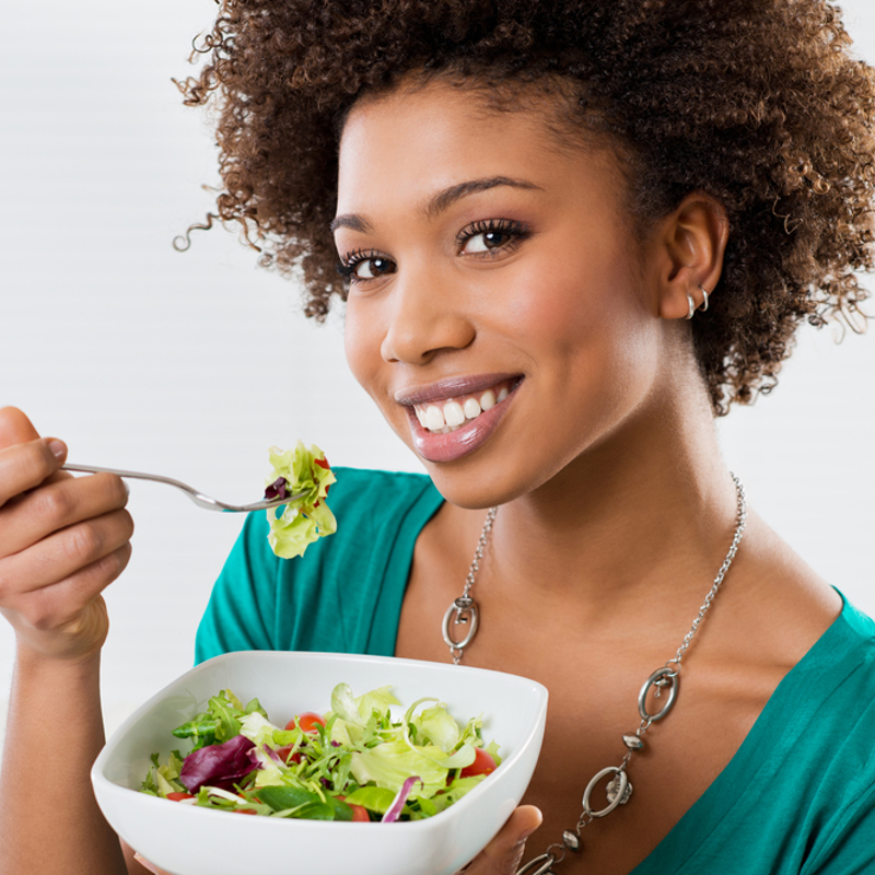 A teenage girl eating a salad