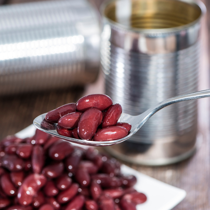 A spoon of red kidney beans from a can