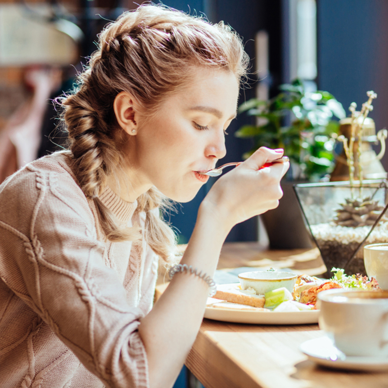 A woman eating a meal in a cafe