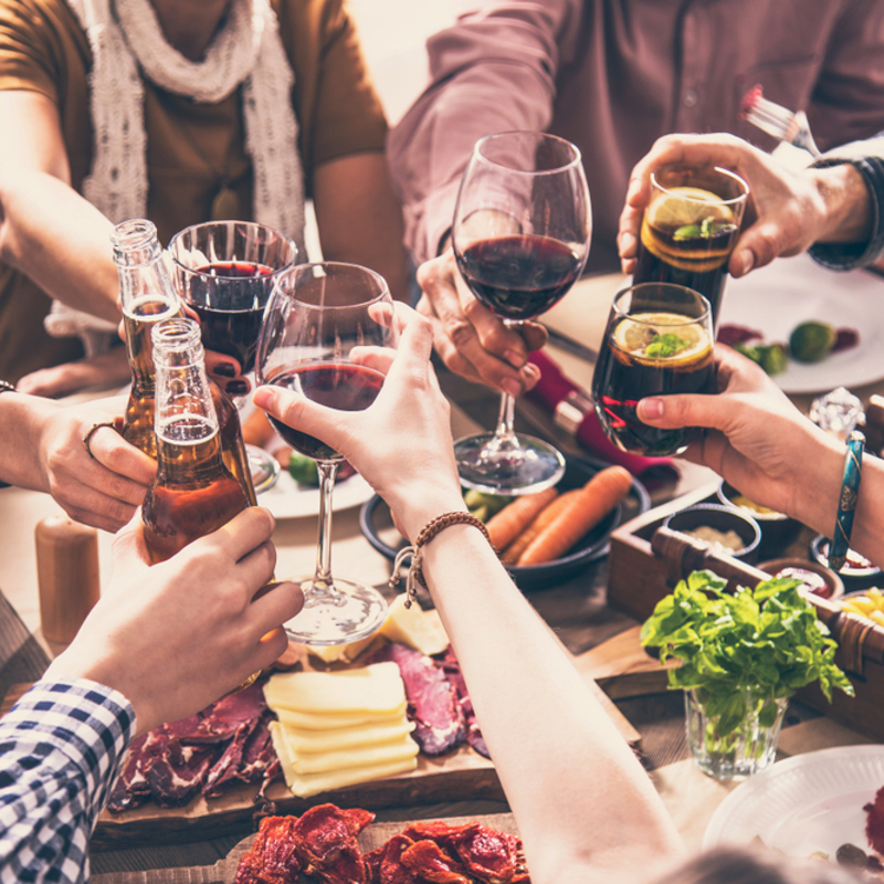 A group of adults having alcoholic drinks together in a restaurant