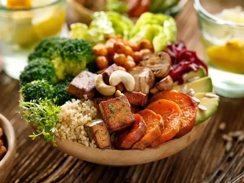 vegan buddha bowl, containing sweet potato, couscous, broccoli and other vegetables loading=